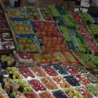 بسطة فواكه في محل بالكويت، صناديق تفاح وبرتقال وعنب وخوخ مرتبة في صفوف