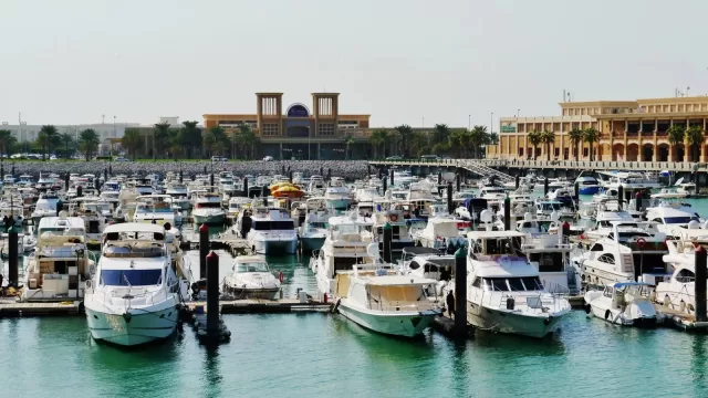 قوارب راسية في مرسى بحري على واجهة مدينة الكويت
