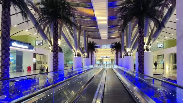 صالة الركاب في مطار الكويت الدولي بنخيلها واضاءتها الزرقاء