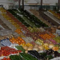 بسطة خضار وفواكه مرتبة في صفوف داخل سوق مسقوف في الكويت