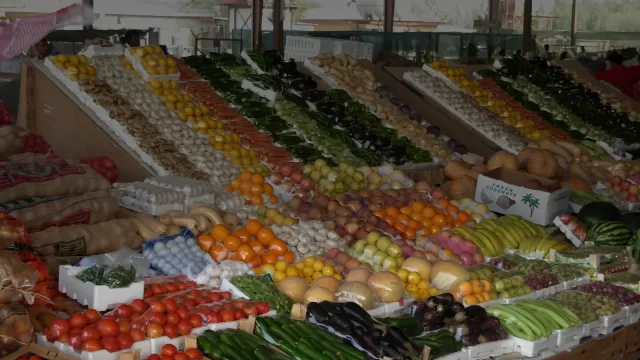 بسطة خضار وفواكه مرتبة في صفوف داخل سوق مسقوف في الكويت