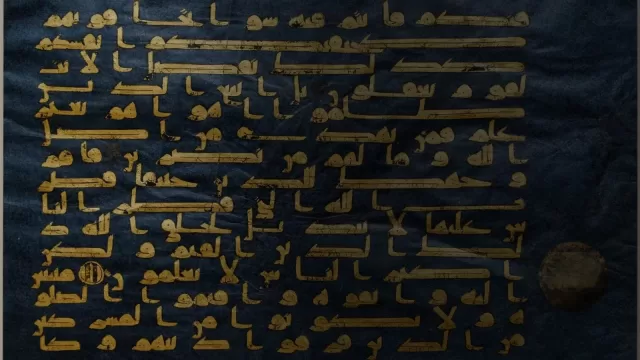 ورقة من مصحف مكتوبة بالخط الكوفي بماء الذهب على رق مصبوغ بالنيلي
