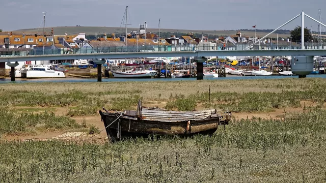 An abandoned wooden boat at a mooring