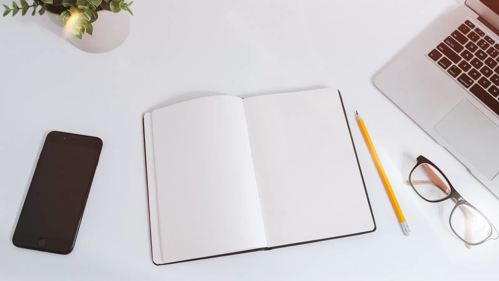 هاتف ودفتر على طاولة مكتب