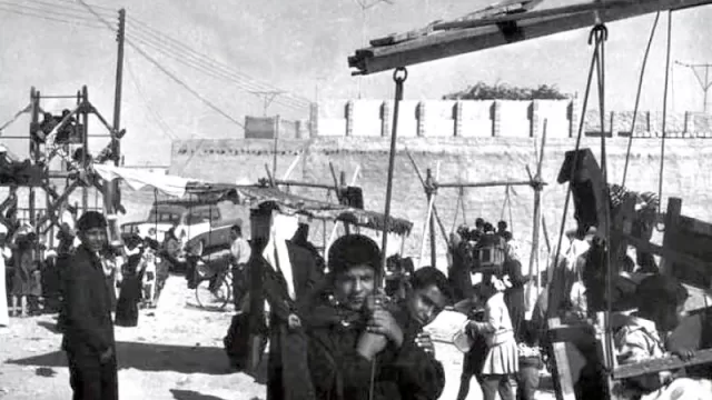 Children playing a traditional street game on sandy ground