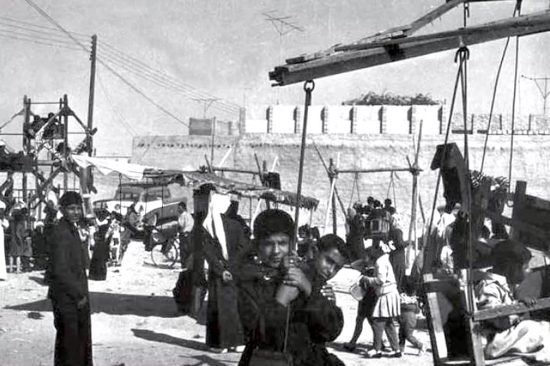 Children playing a traditional street game on sandy ground