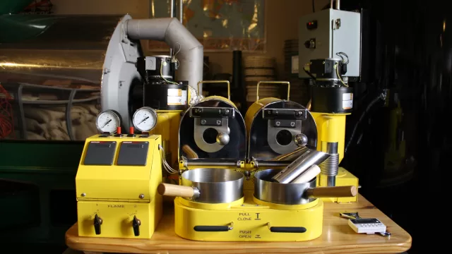 A drum coffee roaster in a roastery. Source: Wikimedia Commons, File:Coffee Roaster.JPG. Photographer: Stevenbrooklyn. L