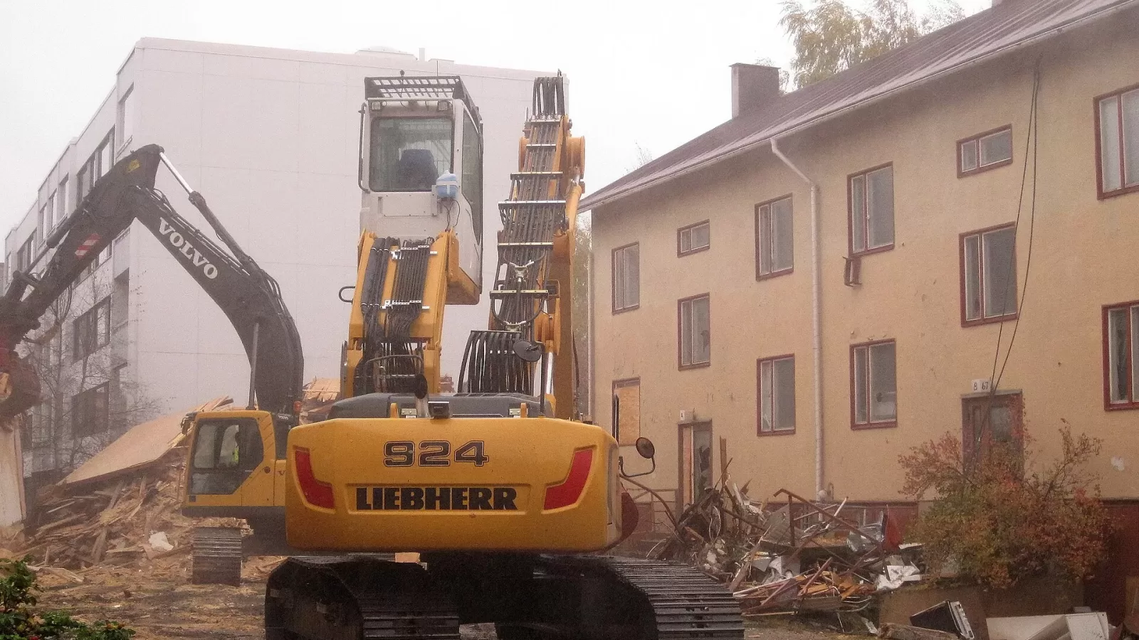 An excavator demolishing an old building