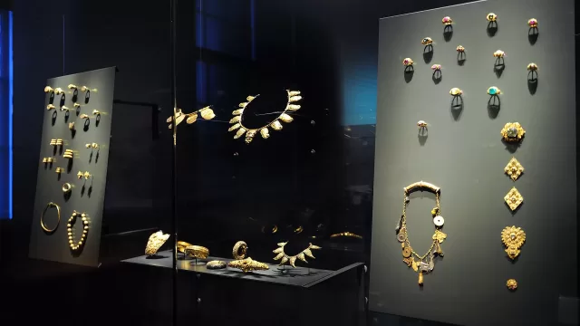 Gold jewellery arranged in a display case