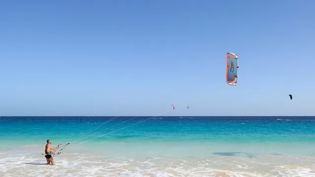 A kitesurfer over shallow water