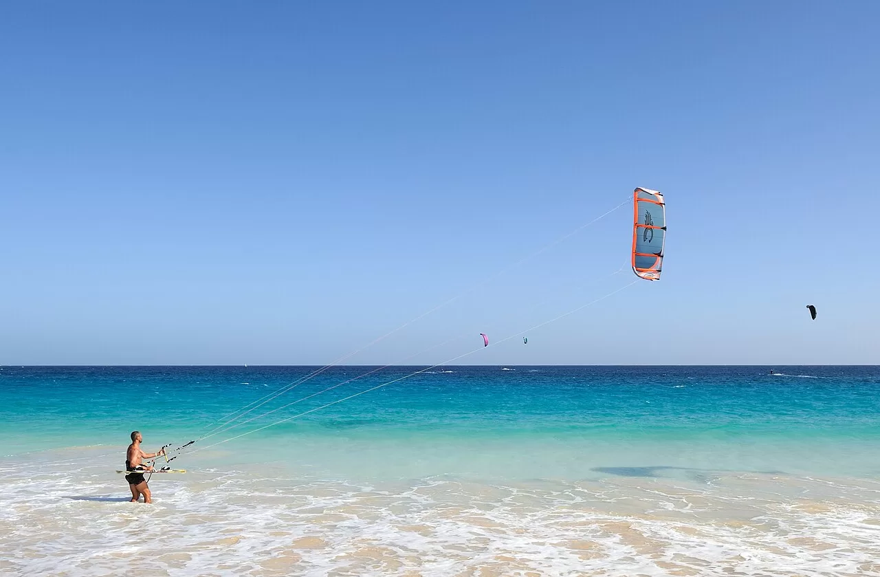 A kitesurfer over shallow water
