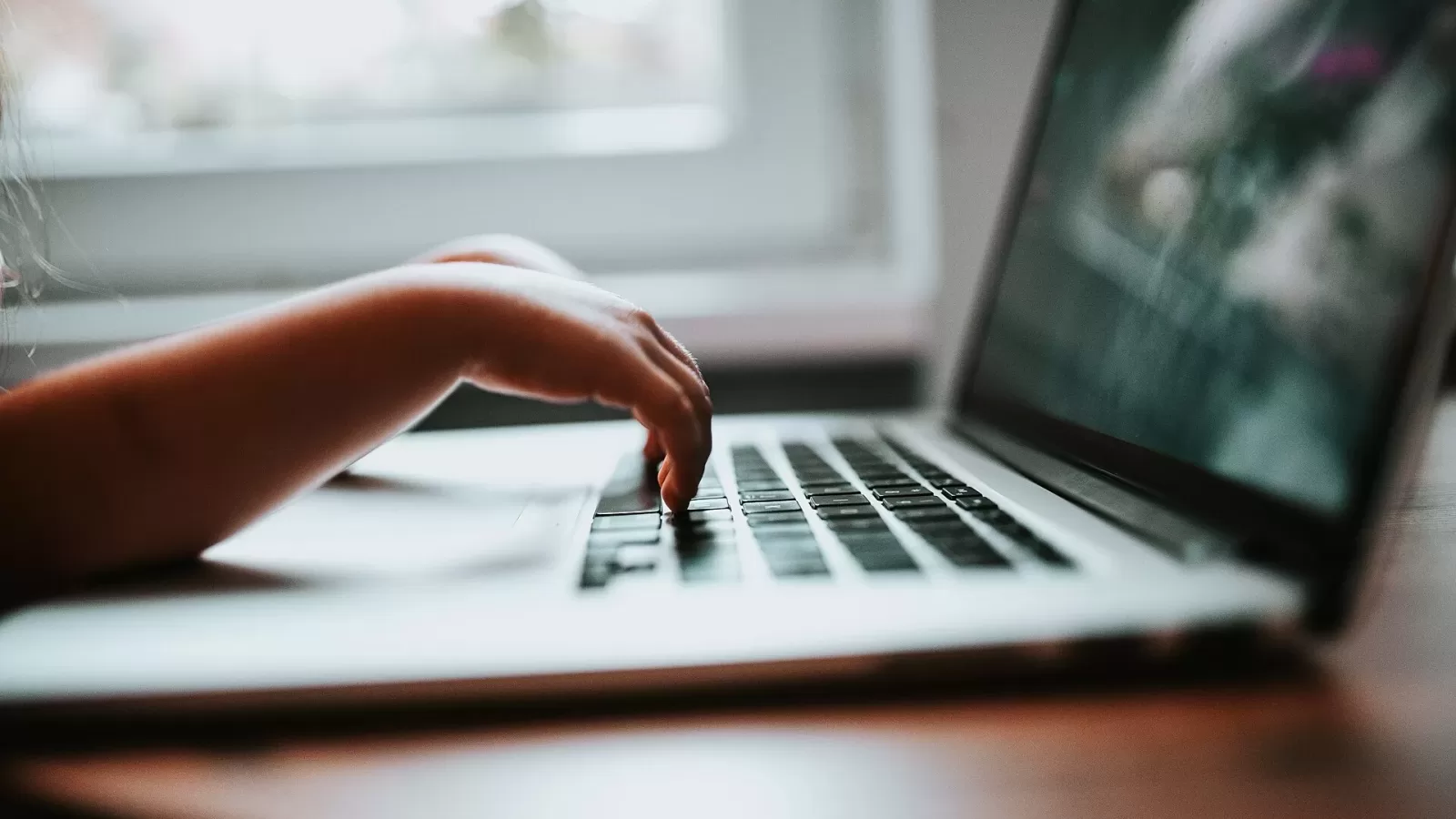 Two hands typing on a laptop keyboard