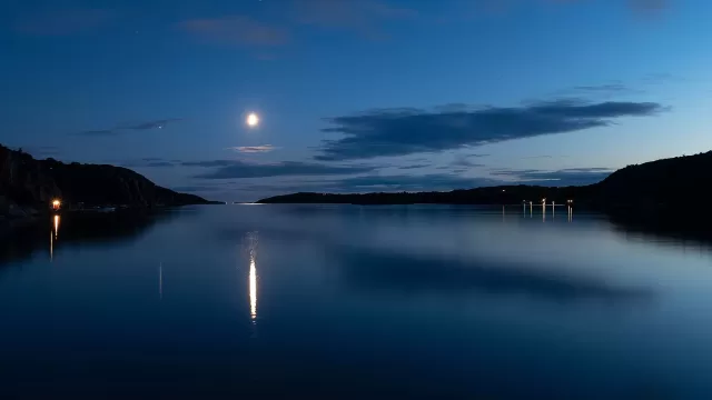 The moon above water at night