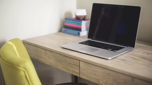 حاسوب محمول مفتوح على مكتب خشبي