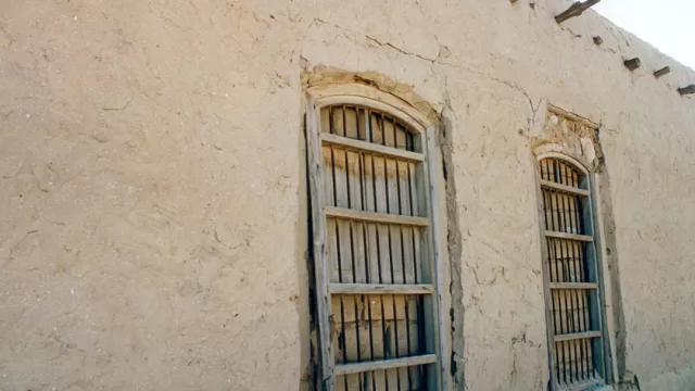 A narrow lane between mud-brick houses in an old Kuwaiti neighbourhood