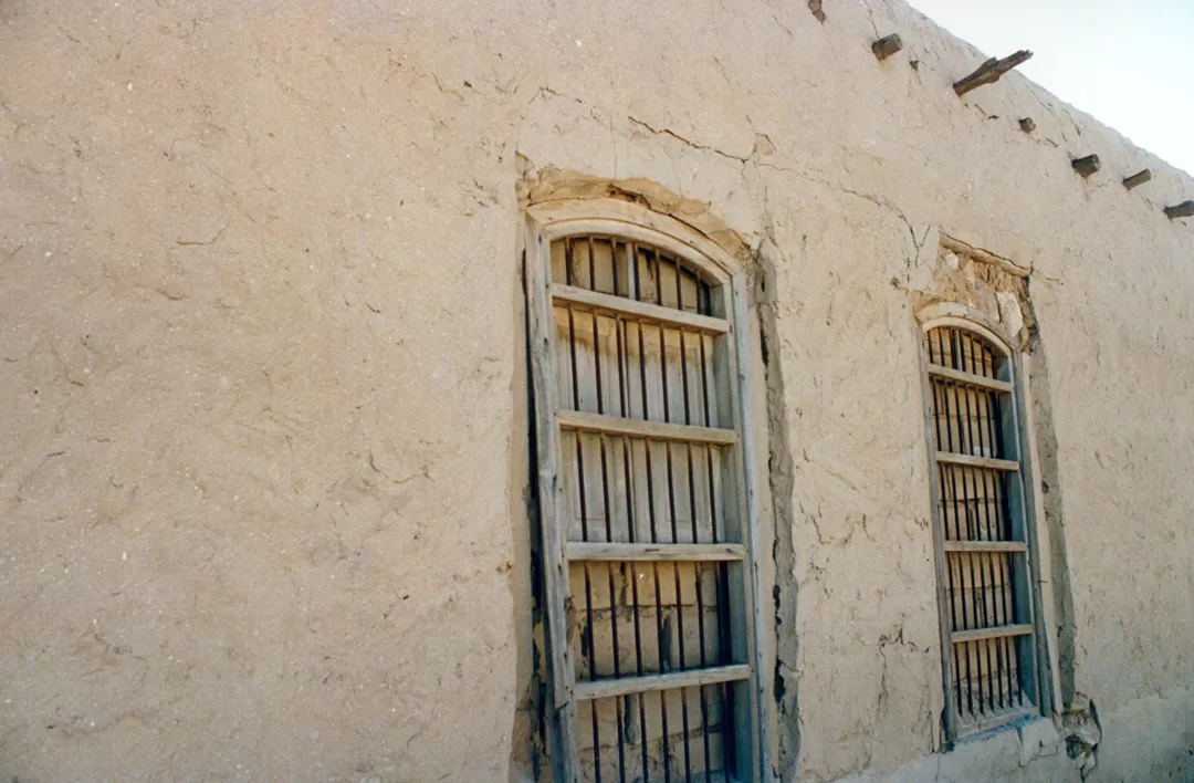 A narrow lane between mud-brick houses in an old Kuwaiti neighbourhood