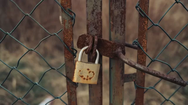 A metal padlock securing a gate