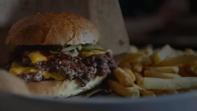 A smash burger served with a portion of fries
