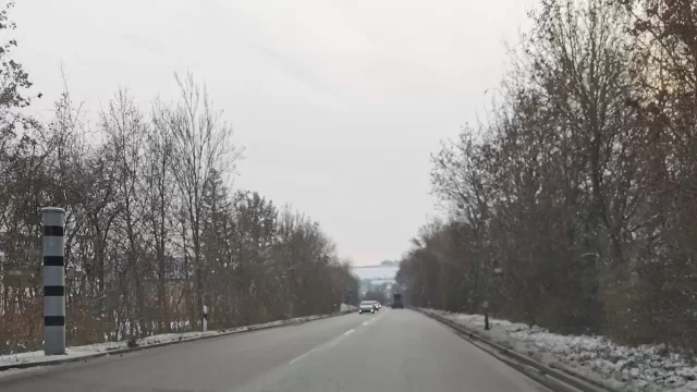 A speed camera on a pole beside a road