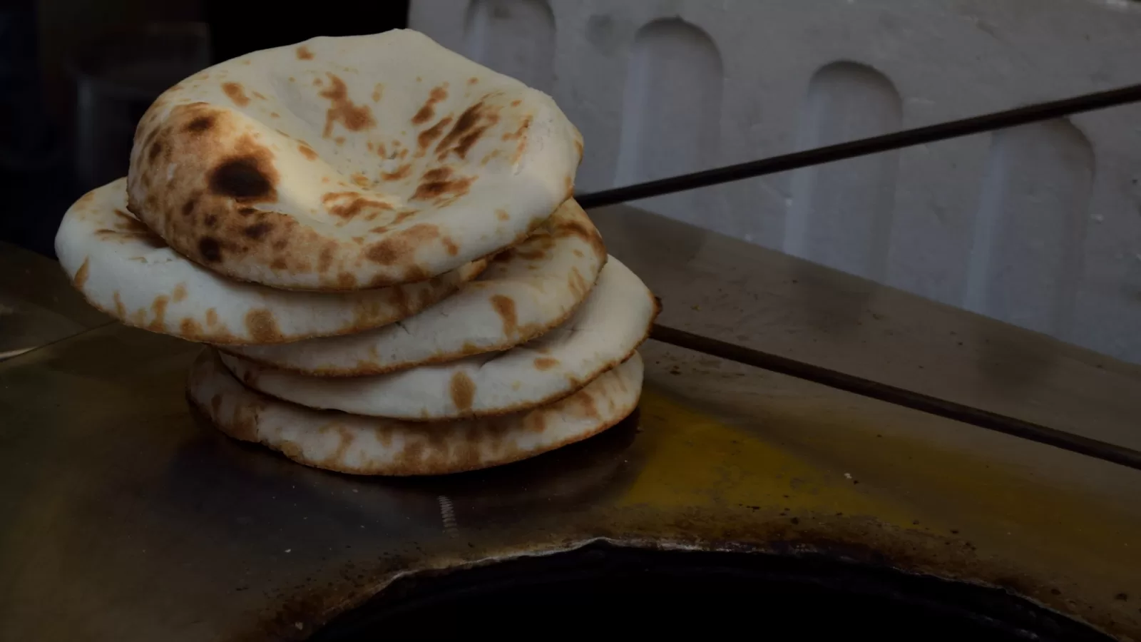 ارغفة خبز على فوهة تنور طيني