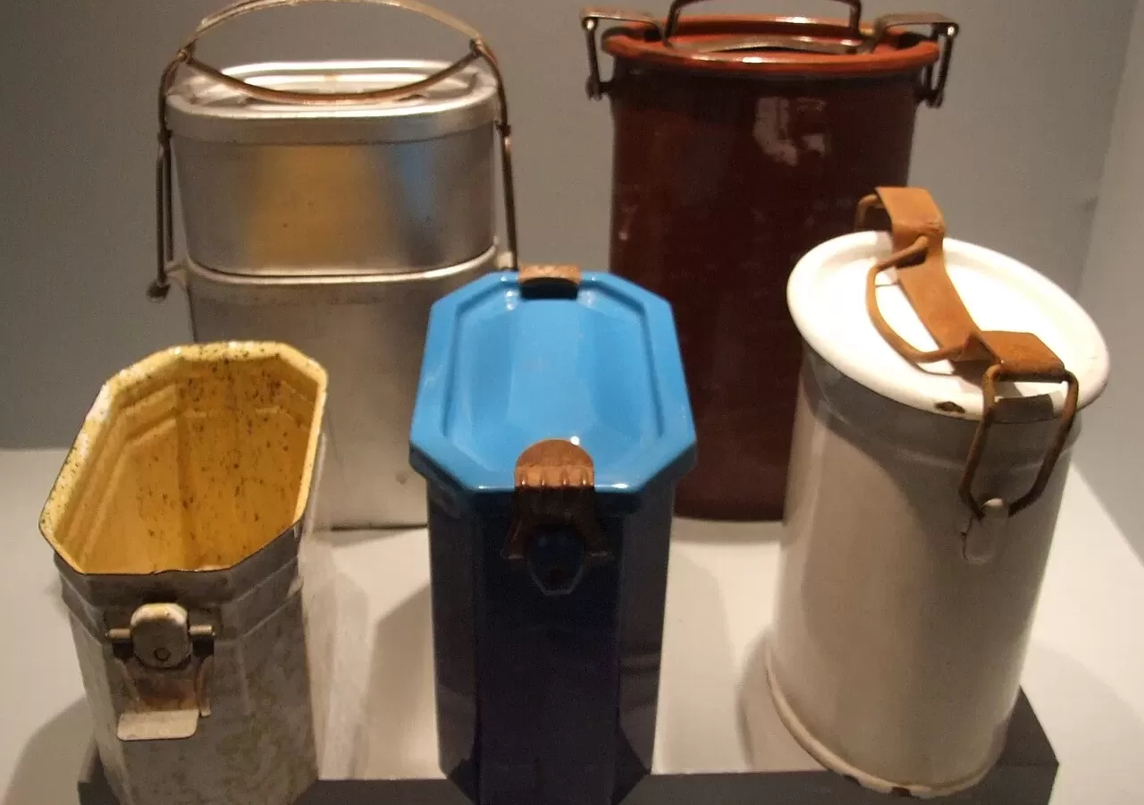 A row of stacked metal tiffin carriers with handles