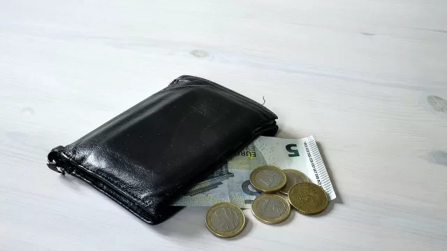A wallet with coins beside it