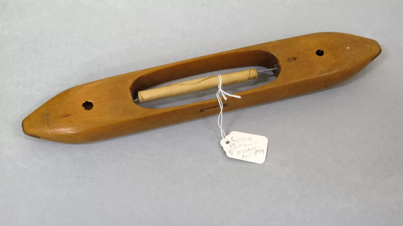 A wooden weaving shuttle