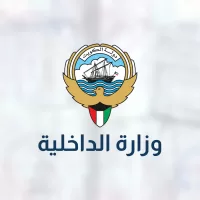 شعار دولة الكويت وتحته اسم وزارة الداخلية على خلفية مموهة
