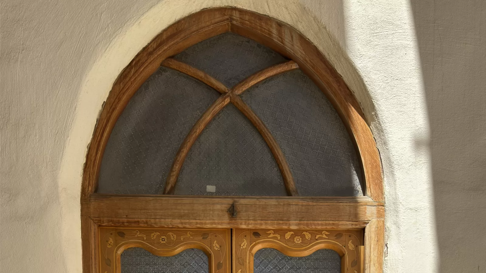 Old carved wooden door with arched glass in a Kuwaiti house