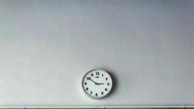 ساعة حائط على جدار ابيض