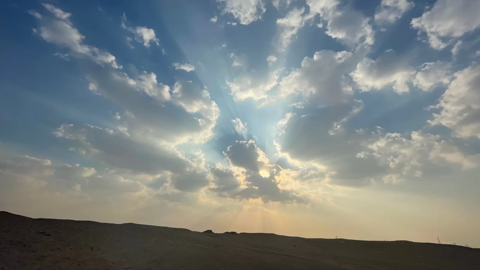 غيوم وشعاع شمس فوق الصحراء