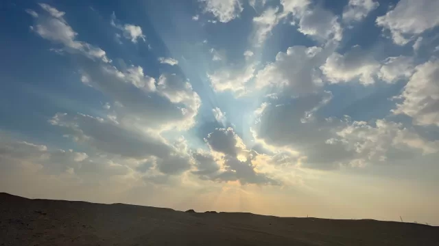 غيوم وشعاع شمس فوق الصحراء